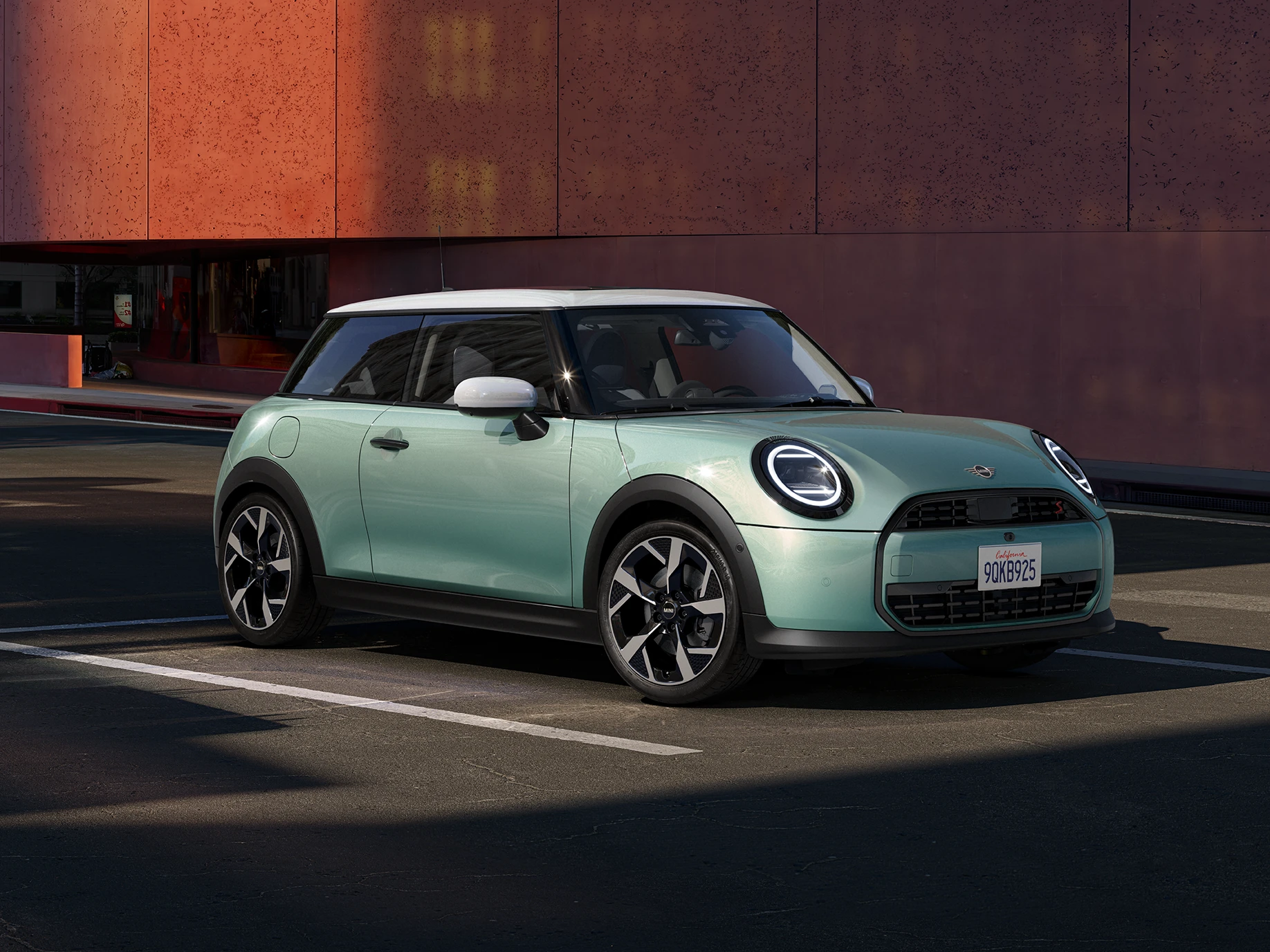 Boční pohled zepředu na MINI Cooper v zelené barvě Ocean Wave Green a bílou střechou.