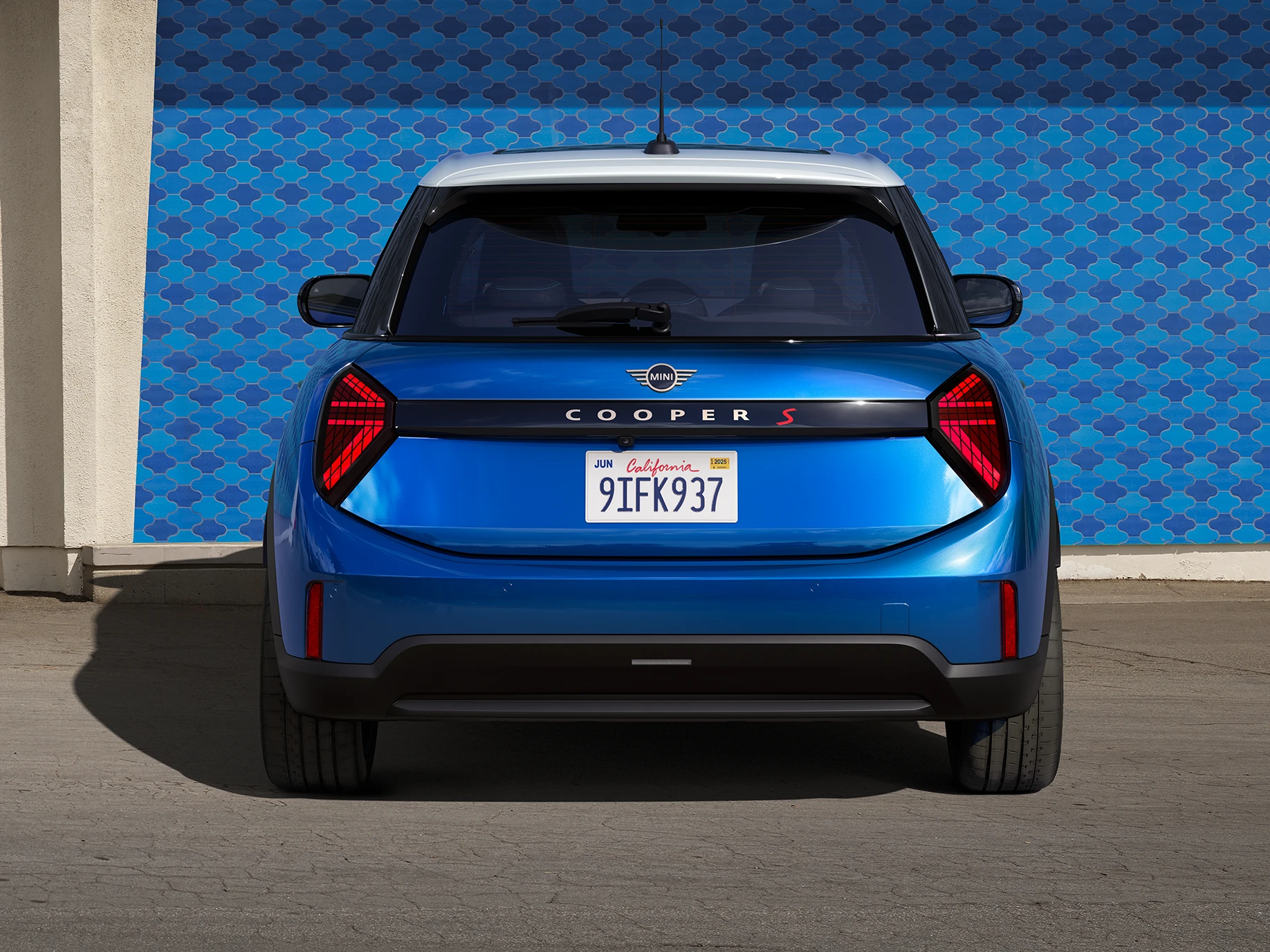 Pohled zezadu na 5dveřové MINI Cooper v modré barvě Icy Sunshine Blue s modrou barevnou střechou Multitone.