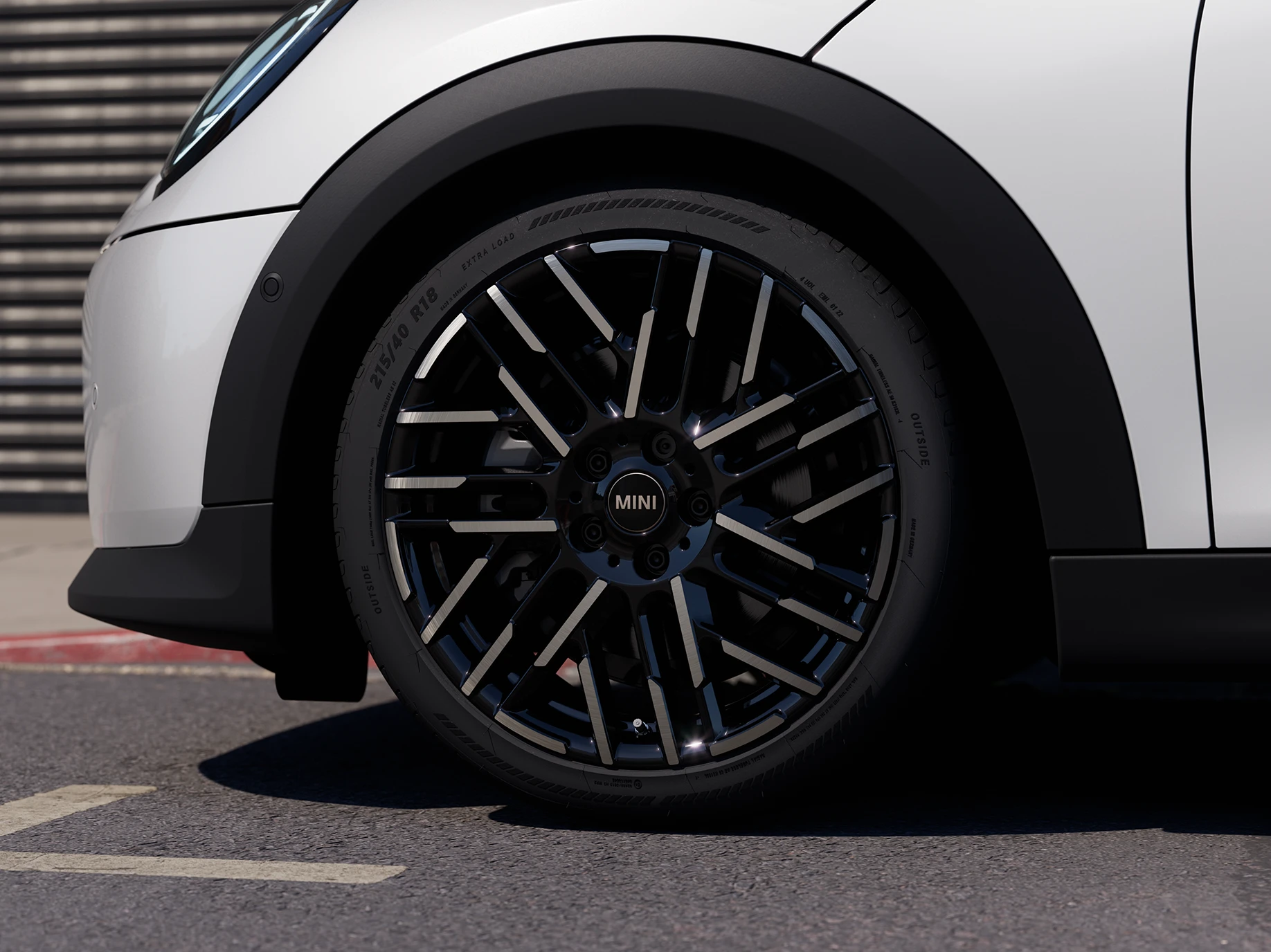 Detailní pohled na 5dveřové MINI Cooper v bílé barvě Nanuq White s dvoubarevnými koly Night Flash Spoke.