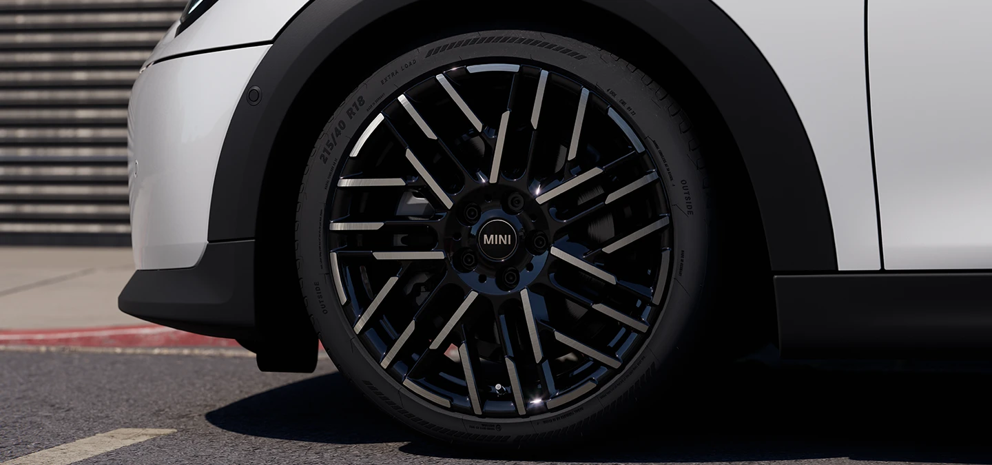 Detailní pohled na 5dveřové MINI Cooper v bílé barvě Nanuq White s dvoubarevnými koly Night Flash Spoke.