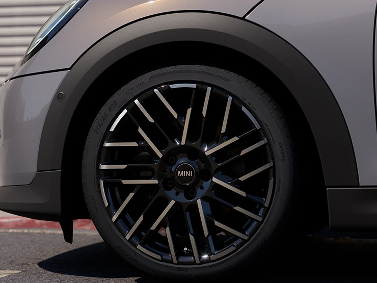 Detailní pohled na MINI Cooper Cabrio v šedé barvě Copper Grey s dvoubarevnými koly Night Flash Spoke.