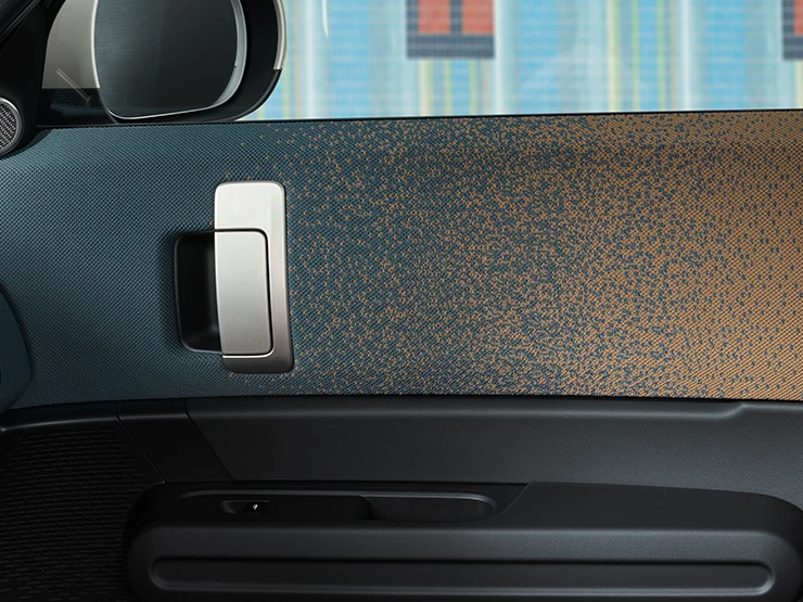 Detailní pohled na design interiéru elektrického MINI Countryman se zaměřením na dveře a palubní desku.