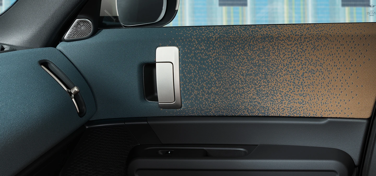 Detailní pohled na design interiéru elektrického MINI Countryman se zaměřením na dveře a palubní desku.