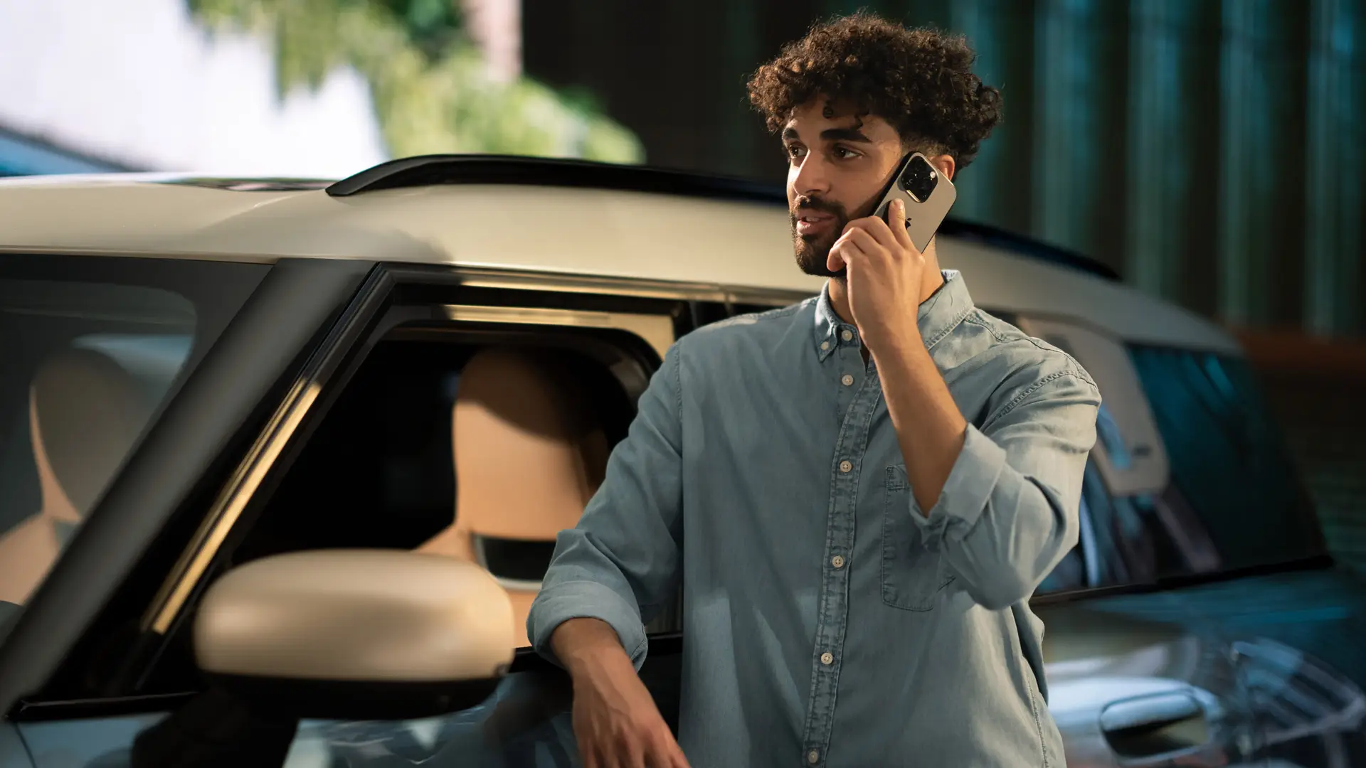 MINI Proaktivní péče – muž stojí u boku svého MINI a telefonuje s konzultantem servisního centra.