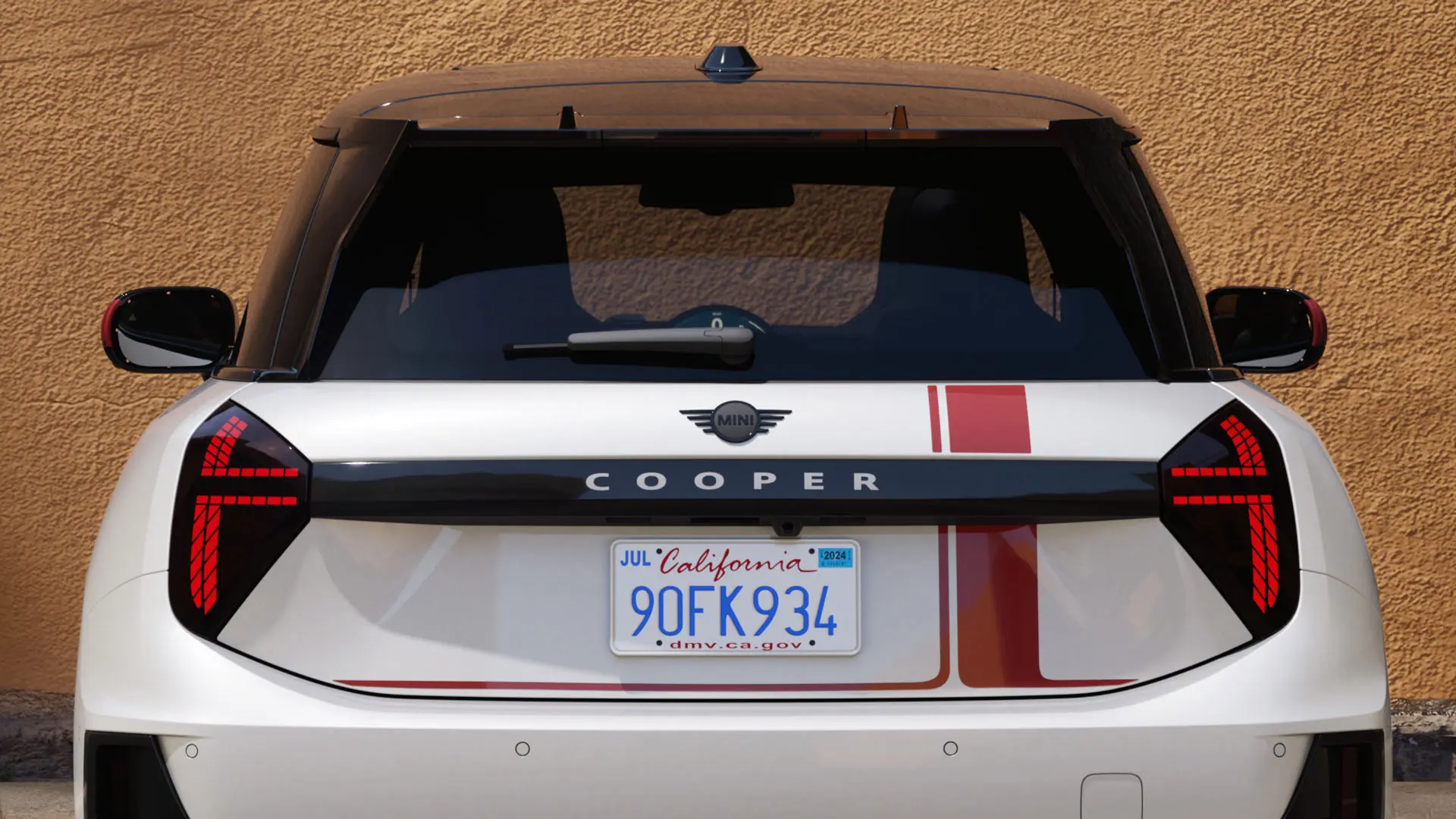 Třídveřové MINI Cooper s polepy MINI John Cooper Works v červené barvě Chili Red – pohled zezadu. 