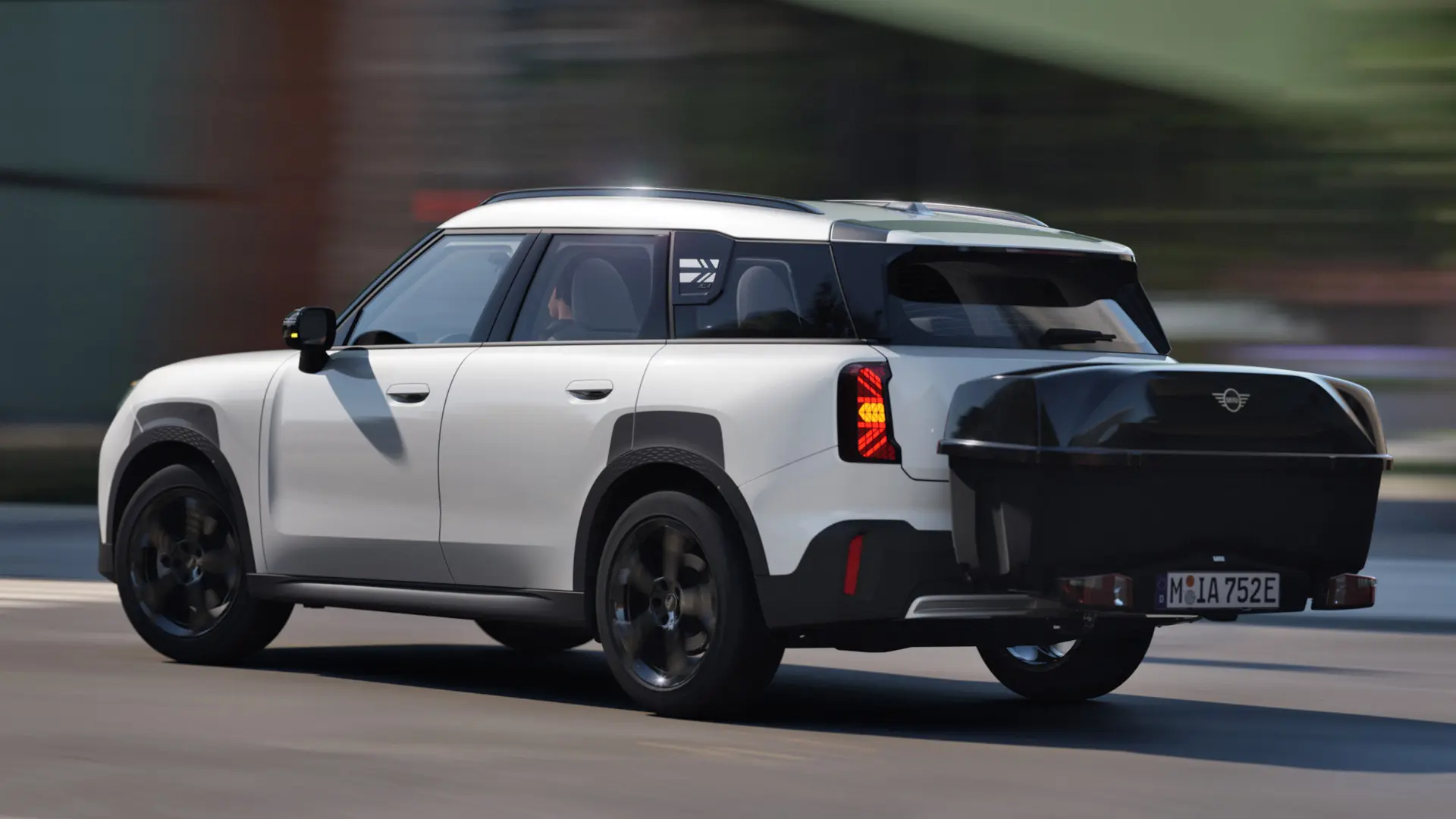 Zadní boční pohled na MINI Aceman v bílé barvě Nanuq White vybavené MINI Zadním nosičem kol a MINI Zadním boxem. 