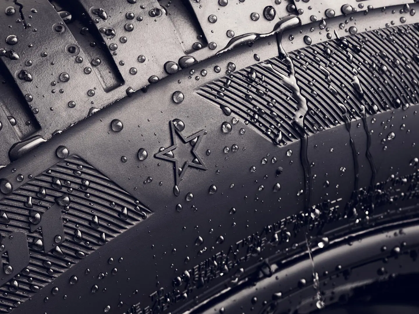 Detailní pohled na bočnici pneumatiky se symbolem hvězdy, který označuje, že tato splňuje požadavky na optimální jízdní vlastnosti u vozidel MINI. 