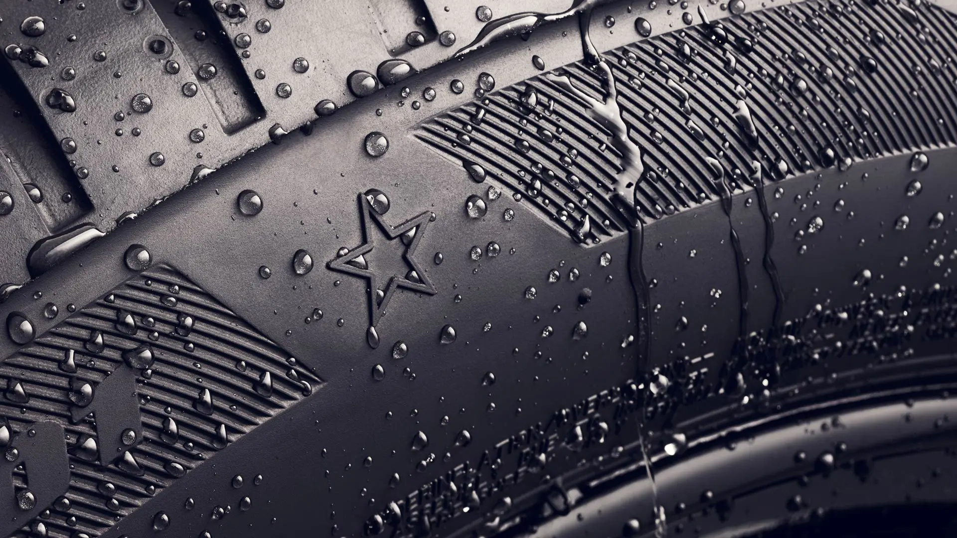 Detailní pohled na bočnici pneumatiky se symbolem hvězdy, který označuje, že tato splňuje požadavky na optimální jízdní vlastnosti u vozidel MINI. 