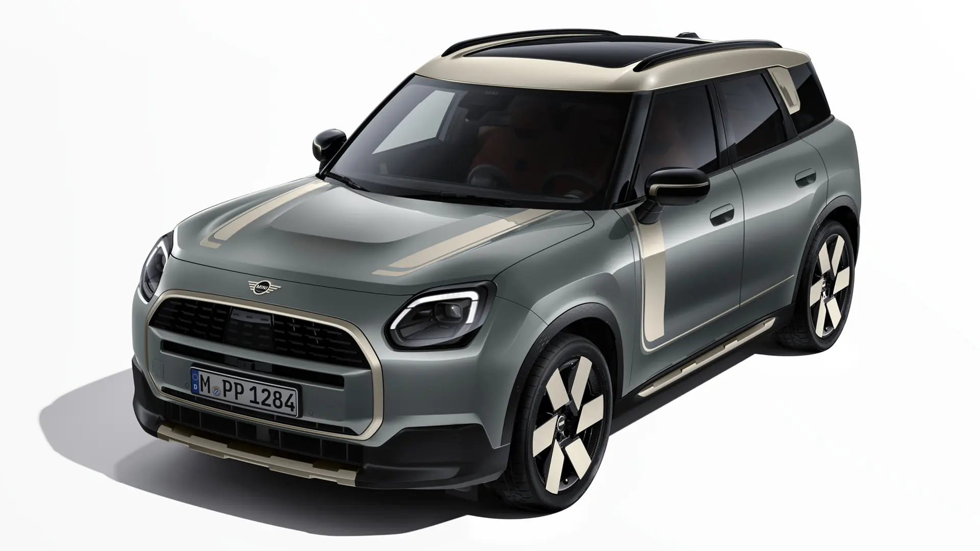Elektrické MINI Countryman v zelené barvě Smokey Green s polepy MINI Favoured ve stříbrné barvě Vibrant Silver, tříčtvrteční pohled.