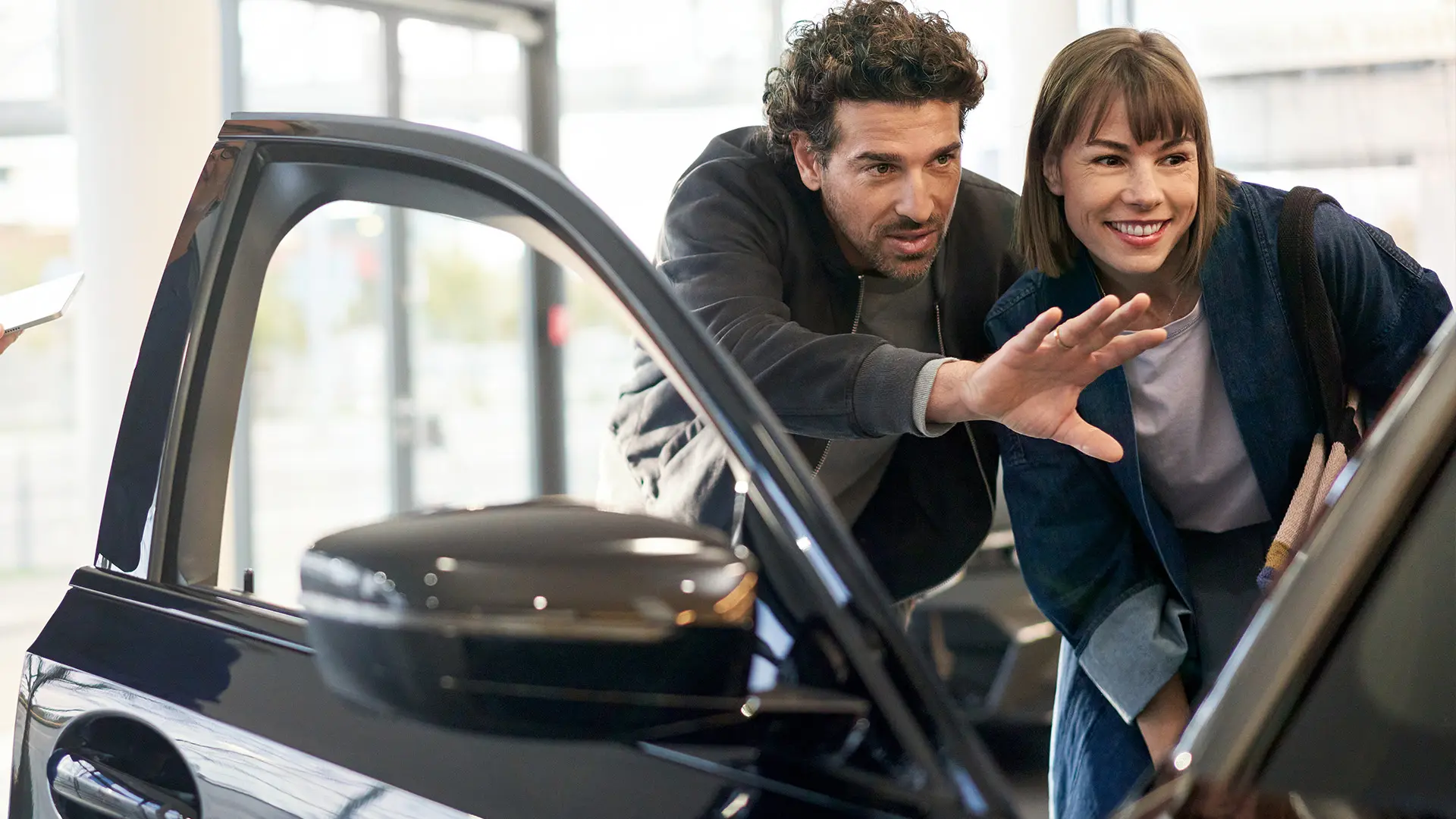 MINI uvnitř MINI Autorizovaného Dealera s poradcem, který radí zákazníkovi a vysvětluje funkce interiéru.