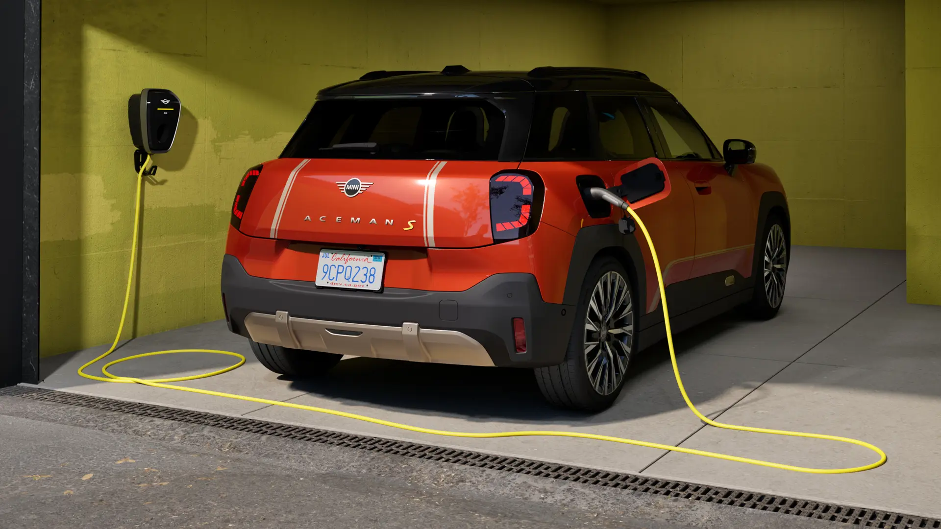 Čistě elektrické MINI Aceman S nabíjené pomocí nabíječky MINI Wallbox Plus, pohled zezadu, zaparkované v garáži.