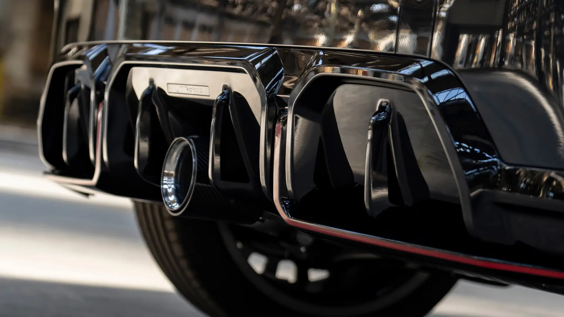 MINI John Cooper Works zadní difuzor v leskle černém provedení s červeným ozdobným rámečkem.