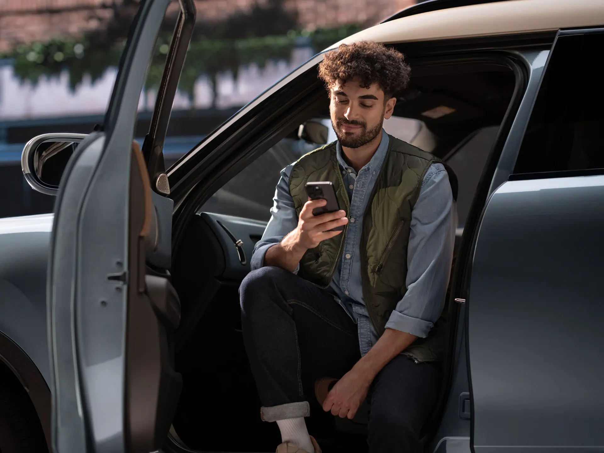 Muž si rezervuje termín servisní prohlídky pomocí mobilního telefonu.