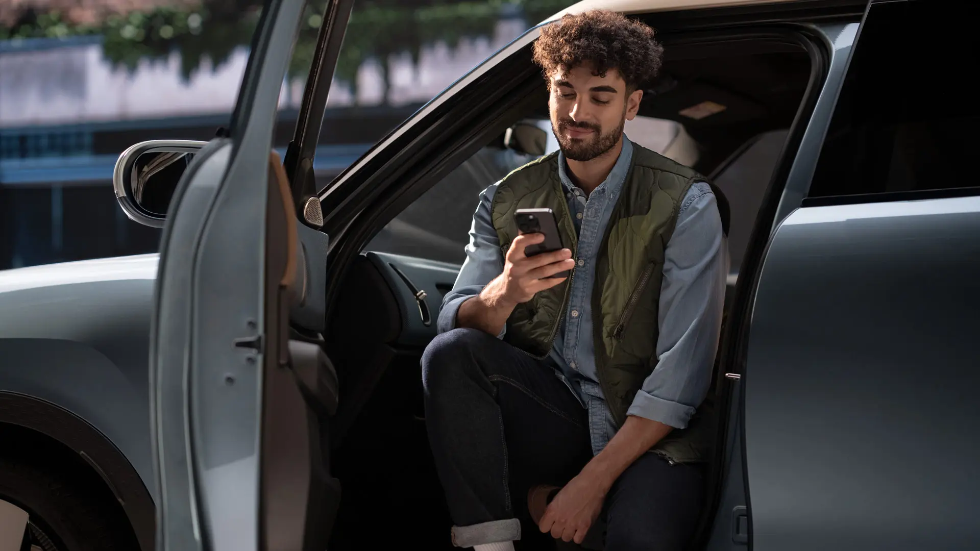 Muž si rezervuje termín servisní prohlídky pomocí mobilního telefonu.