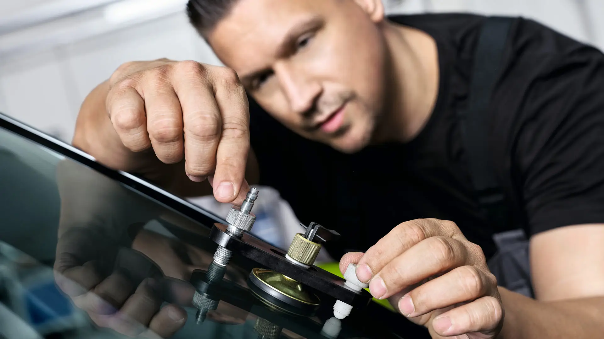 Zaměstnanec MINI opravuje čelní sklo.