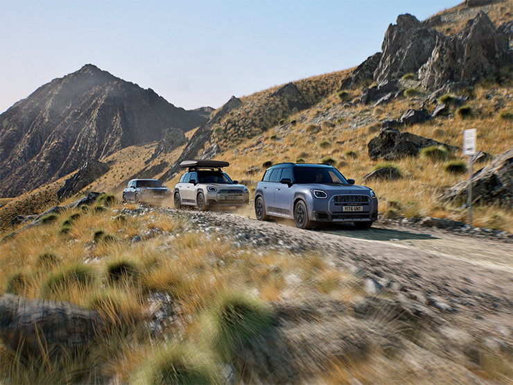 Fotografie několika MINI Countryman Untamed Edition jedoucích v terénu po horských silnicích.