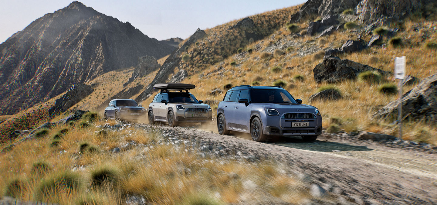 Fotografie několika MINI Countryman Untamed Edition jedoucích v terénu po horských silnicích.