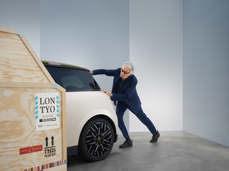 Pohled zezadu na elektrické MINI Cooper Paul Smith Edition v bílé barvě Inspired White s Paulem Smithem za vozem.