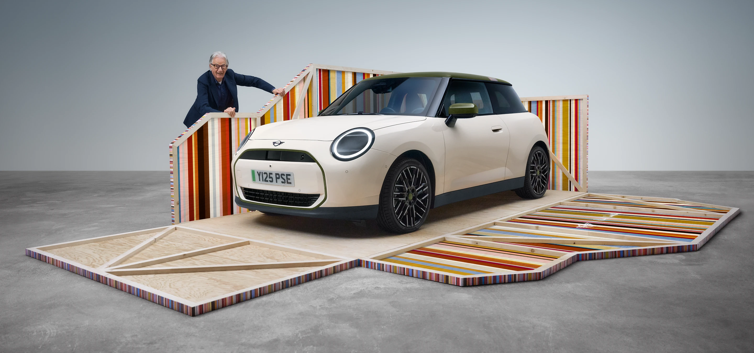 Přední boční pohled na elektrické MINI Cooper Paul Smith Edition v bílé barvě Inspired White s návrhářem Paulem Smithem.