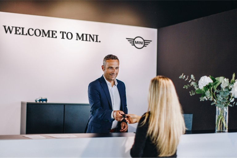 Recepce MINI Autorizovaného Dealera se zaměstnancem a zákazníkem